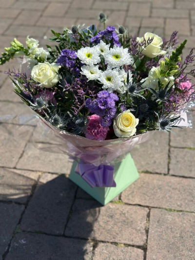 Lavender Whisper - A soft and elegant bouquet blending delicate shades of lavender, crisp white, and gentle blush tones. Accented with textured greenery and subtle silvery elements, this arrangement has a light, airy feel with a touch of rustic charm. Beautifully wrapped and finished with a coordinating ribbon, it’s perfect for thoughtful gifts, special occasions, or adding a calm and graceful presence to any space.