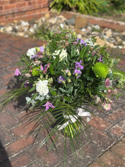 Wild Meadow Whisper - A natural and free-flowing bouquet inspired by the beauty of a countryside meadow. Featuring a fresh blend of soft purples, crisp whites, and vibrant green accents, this arrangement has a relaxed, airy feel with plenty of texture and movement. Flowing foliage and delicate details create an organic, untamed look, while the simple finish keeps it effortlessly elegant. Perfect for nature lovers, thoughtful gifts, or adding a touch of rustic charm to any setting.