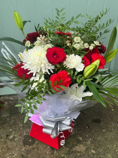 Crimson & Ivory - A timeless and elegant bouquet featuring a striking contrast of rich crimson tones and crisp ivory accents, beautifully balanced with fresh greenery. Designed in a full, rounded style, this arrangement offers depth, texture, and a refined sense of harmony. Finished with a polished wrap and a sleek coordinating bow, it’s perfect for romantic gestures, special occasions, or sending a sophisticated and heartfelt gift.