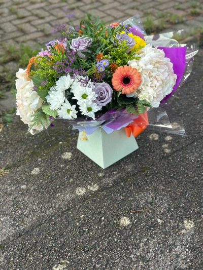 Summer Petals - A lively and colorful bouquet blending soft pastels with vibrant pops of coral, yellow, and lavender. Designed in a relaxed, garden-inspired style, it features a rich mix of textures, airy greenery, and natural movement for a fresh, just-picked feel. The layered wrapping and bright accents add a playful, modern finish, making it perfect for celebrations, birthdays, or sending a joyful and uplifting gift.