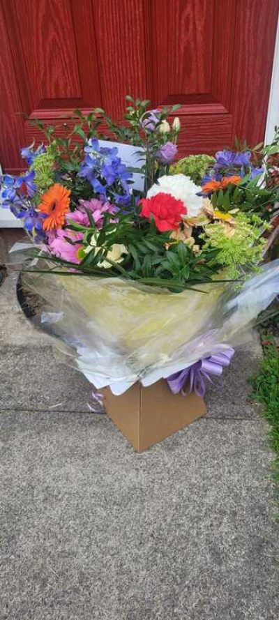Rainbow Garden - A vibrant and joyful bouquet bursting with a playful mix of bright and soft colors. Featuring a lively blend of warm oranges, cool blues, soft pinks, and fresh greens, this arrangement is full of energy and charm. Designed in a relaxed, garden-inspired style, it showcases natural movement and varied textures throughout. Finished with elegant wrapping and a coordinating ribbon, it’s perfect for celebrations, birthdays, or sending a cheerful, uplifting gift.