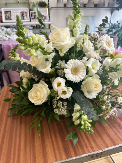 Quiet Comfort Posy - A serene and elegant funeral arrangement designed in soft ivory tones, symbolising purity, peace, and gentle remembrance. Carefully arranged with a mix of delicate textures and lush greenery, this tribute offers a natural, uplifting presence while maintaining a respectful and calming feel. Its classic style makes it a beautiful way to honour a loved one and express heartfelt sympathy.